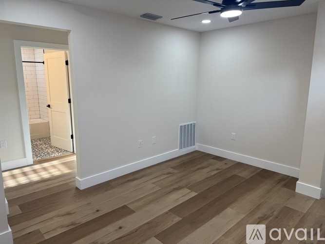 A room with wooden flooring and a ceiling fan.