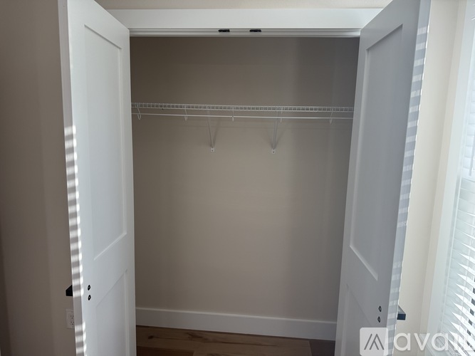 A white closet with a white door and a white shelf.