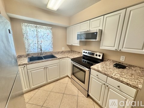 A kitchen with white cabinets and a granite countertop.