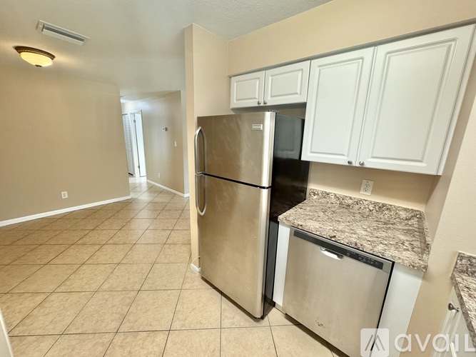 A kitchen with a stainless steel refrigerator and microwave.