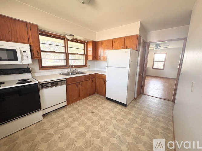 A kitchen with wooden cabinets and a white fridge.