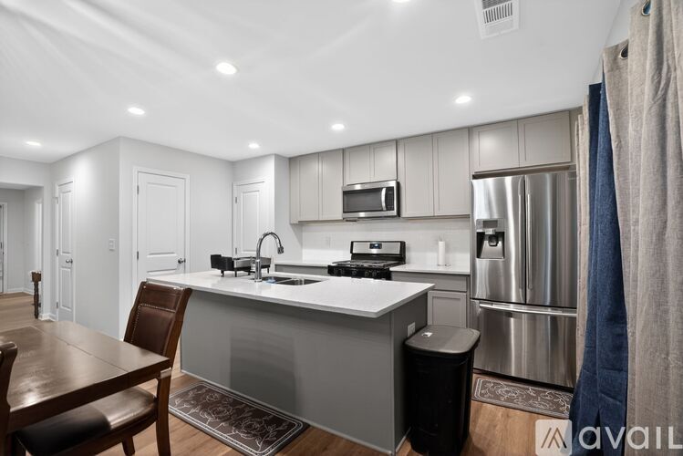A modern kitchen with a wooden table and chairs.