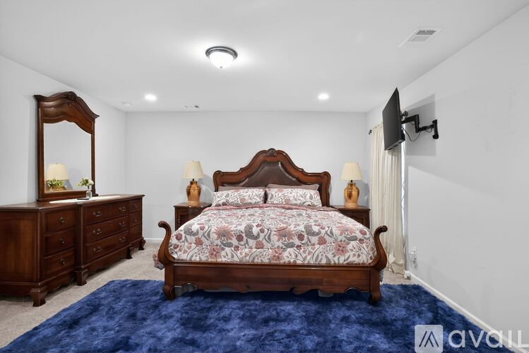 A bedroom with a large bed, a dresser, and a mirror.