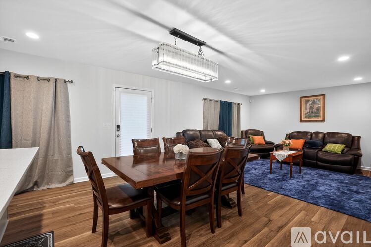A well-lit dining room with a wooden table and chairs.