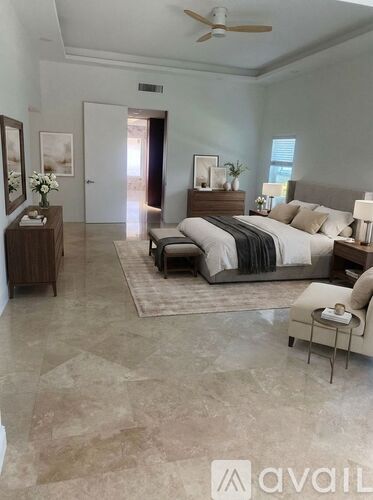 A bedroom with a large bed and a ceiling fan.