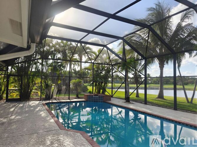 A pool under a glass roof with trees in the background.