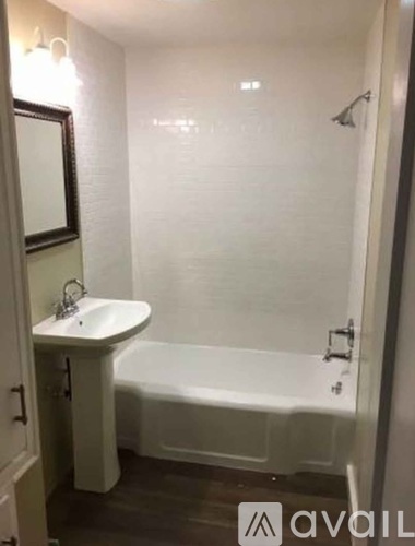 A white bathroom with a sink and bathtub.