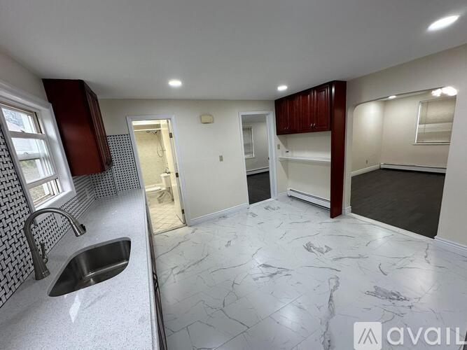 A kitchen with a sink and a marble floor.