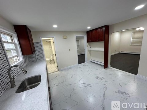 A kitchen with a sink and a marble floor.