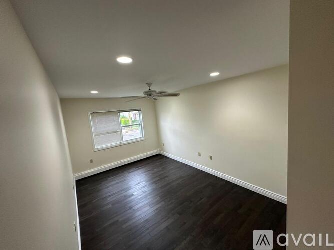 A room with a ceiling fan and a window.