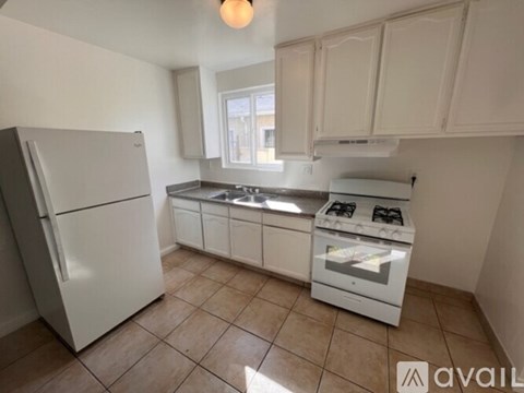 A kitchen with white appliances and cabinets.