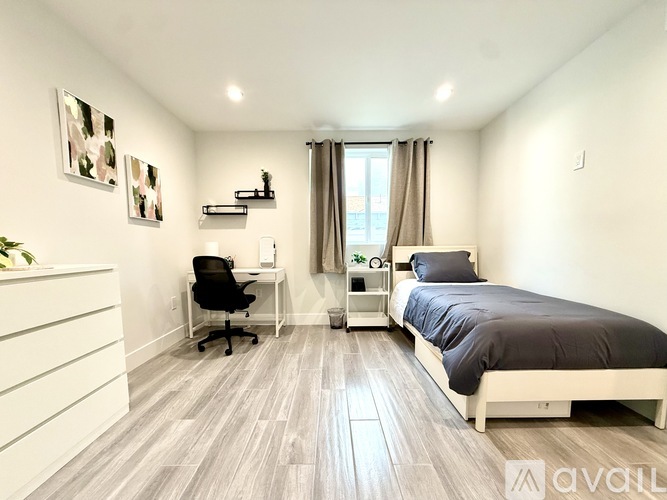 A bedroom with a bed, desk, and chair.