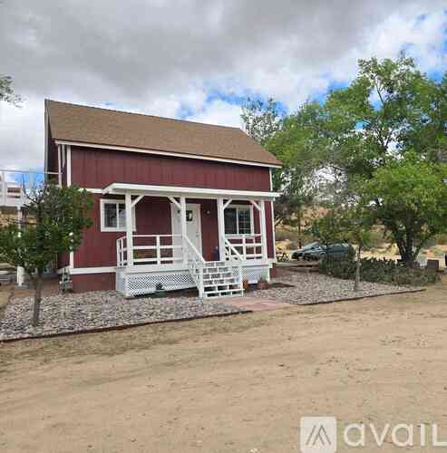 A red barn with white railings and a brown roof.
