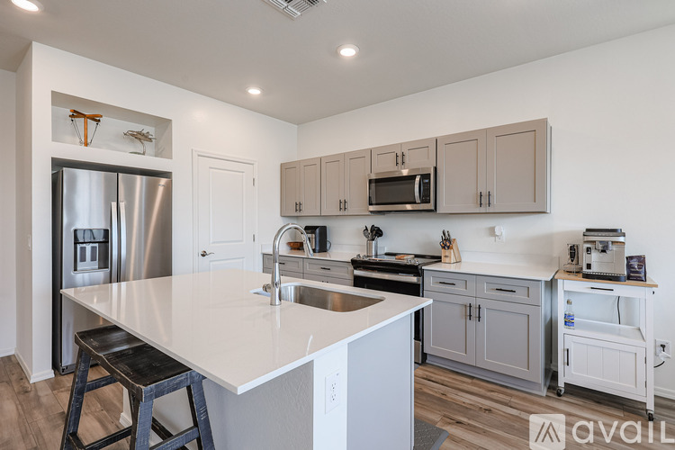 A kitchen with a white countertop and a stainless steel refrigerator.