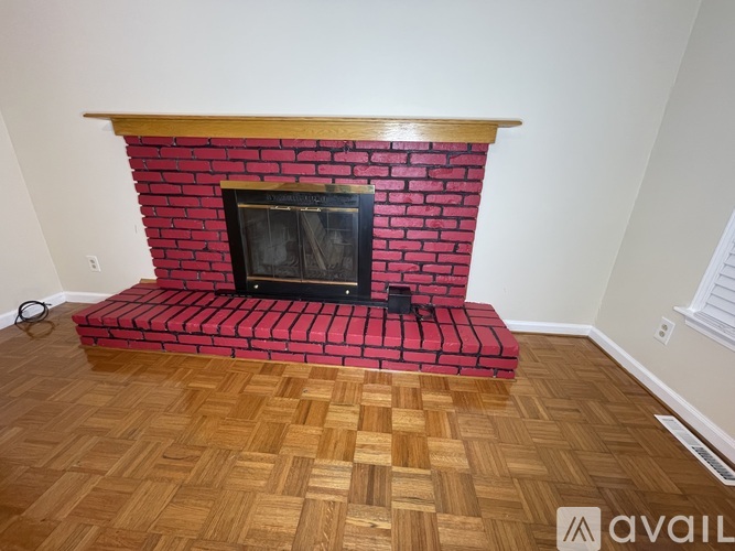 A fireplace with a red brick surround and a black firebox.