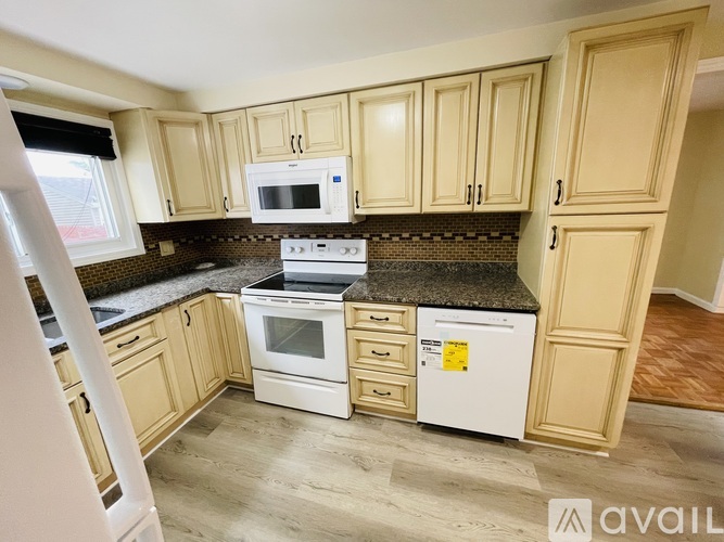 A kitchen with wooden cabinets and a white stove top oven.