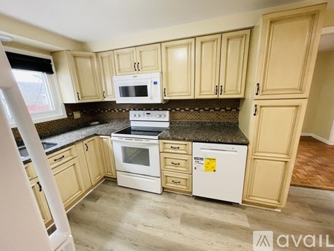 A kitchen with wooden cabinets and a white stove top oven.