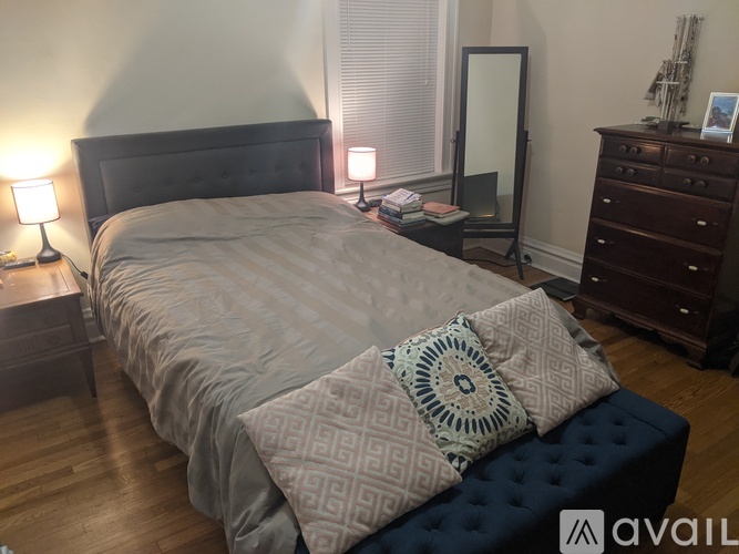 A bedroom with a large bed and a wooden floor.