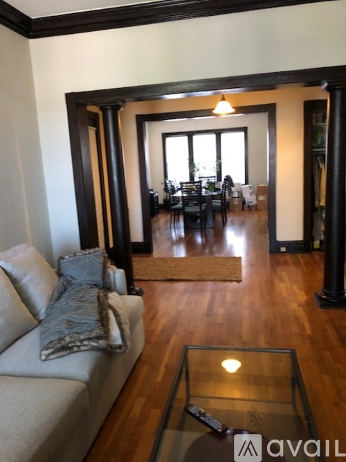 A living room with a couch and a glass coffee table.