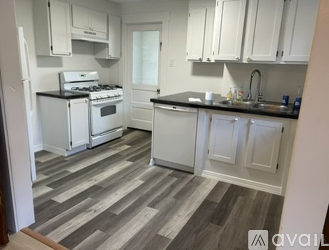 A kitchen with white appliances and cabinets.
