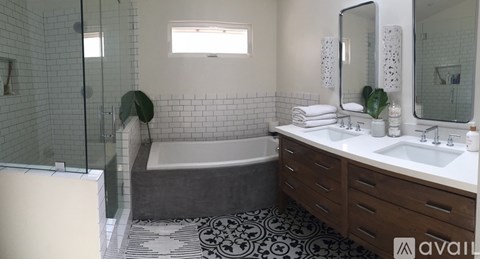 A bathroom with a black and white floor mat and a white sink.