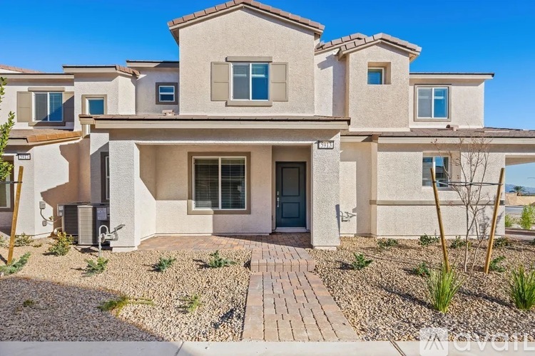 A modern house with a front yard and a driveway.