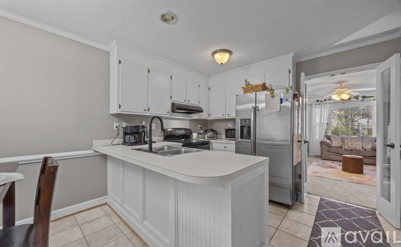 A kitchen with white cabinets and a white island.