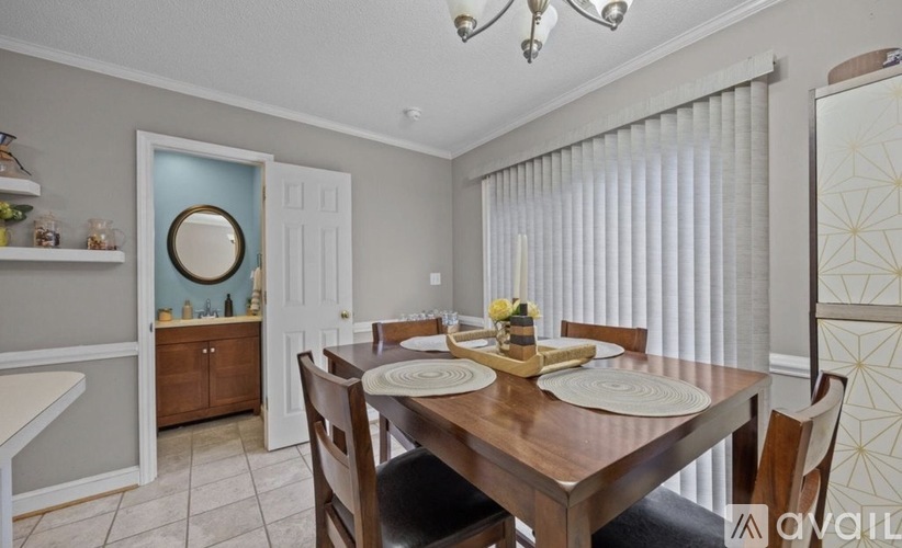 A dining room with a wooden table set for two.