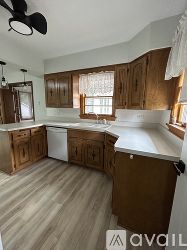 A kitchen with wooden cabinets and a white dishwasher.