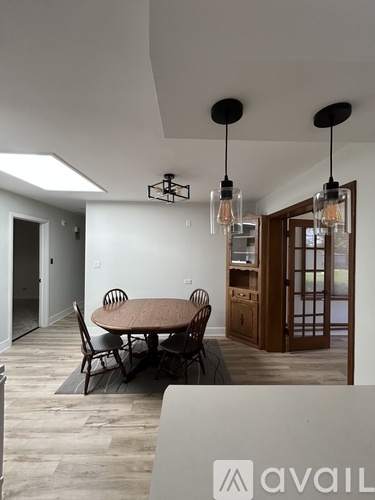 A dining room with a table and chairs.