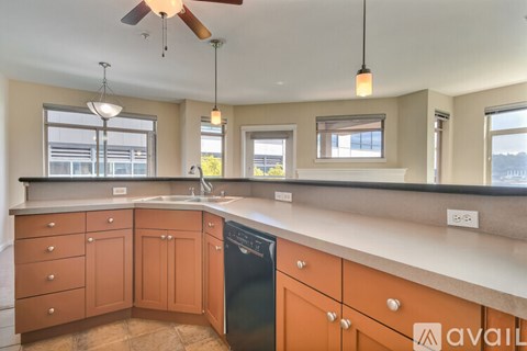 A kitchen with wooden cabinets and a black dishwasher.