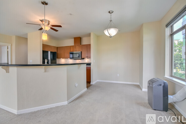 A spacious living room with a bar area and a ceiling fan.