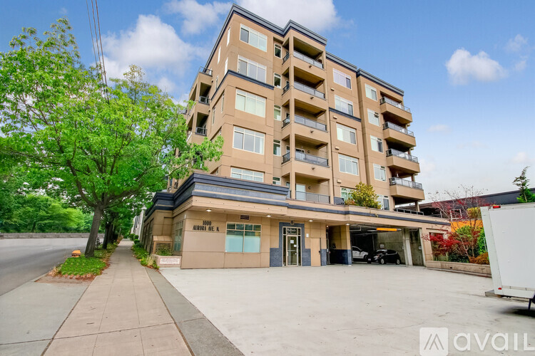 A large apartment building with a parking garage in front.
