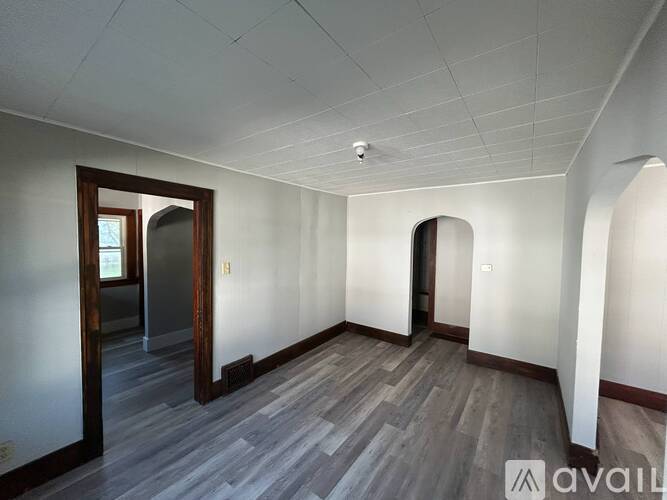 A room with wooden floors and arched doorways.