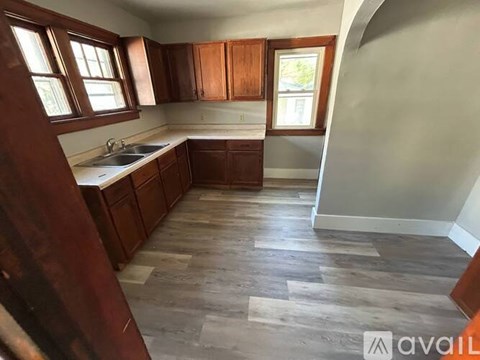 A kitchen with wooden cabinets and a checkered floor.