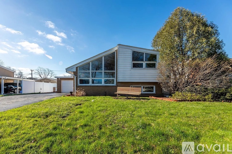 A modern house with a large front yard is for sale.