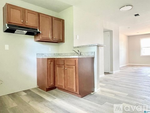 A kitchen with brown cabinets and a marble countertop.