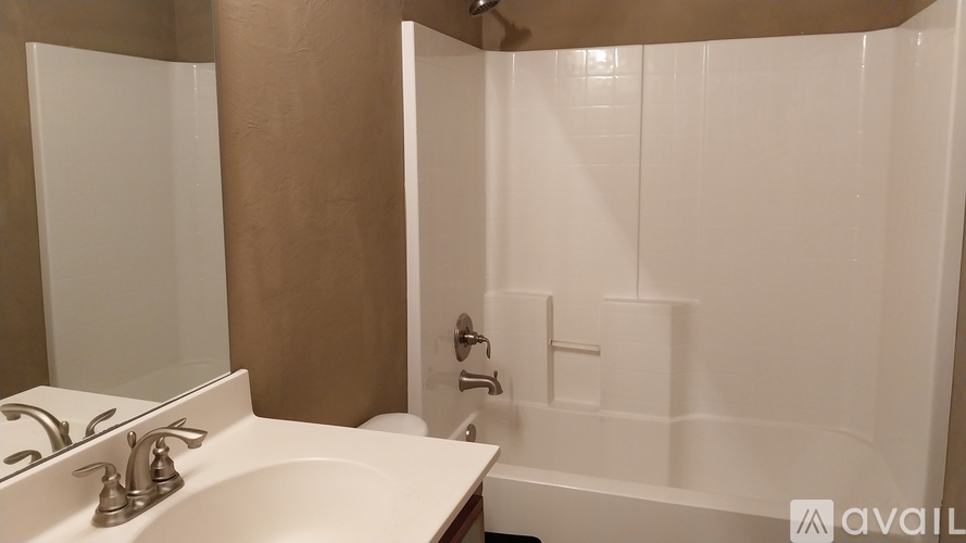 A bathroom with a white sink and a white bathtub.