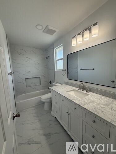 A bathroom with a marble countertop and a walk-in shower.