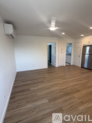 A room with wooden flooring and a ceiling fan.