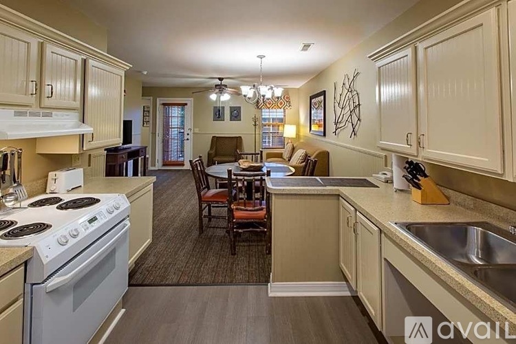 A kitchen with a white stove top oven and a dining table with chairs.
