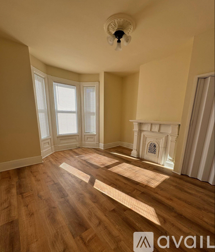 A room with a fireplace and wooden floors.