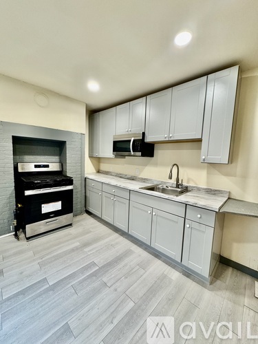 A modern kitchen with a grey floor and white cabinets.