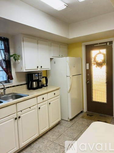 A kitchen with white cabinets and a white refrigerator.