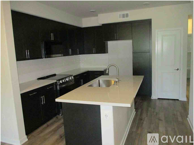 A kitchen with black cabinets and a white island.