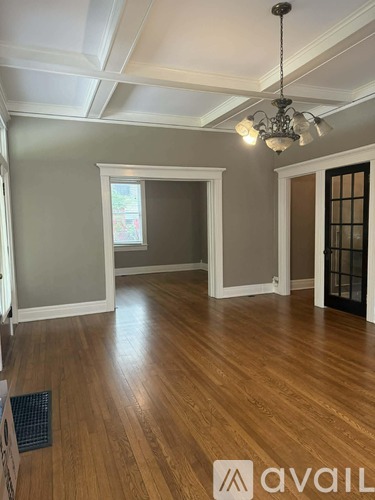 A room with wooden floors and a chandelier.