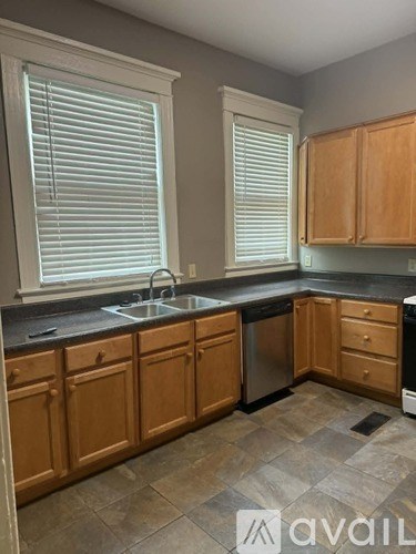 A kitchen with wooden cabinets and a black countertop.