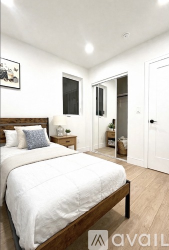 A bedroom with a large bed and a wooden headboard.