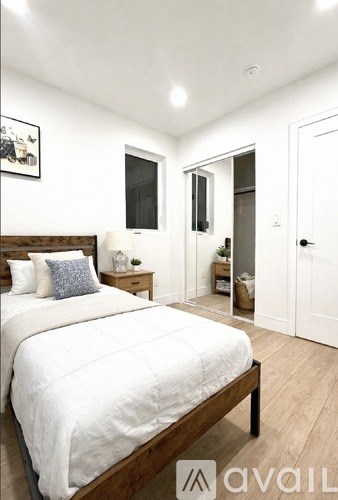 A bedroom with a large bed and a wooden headboard.
