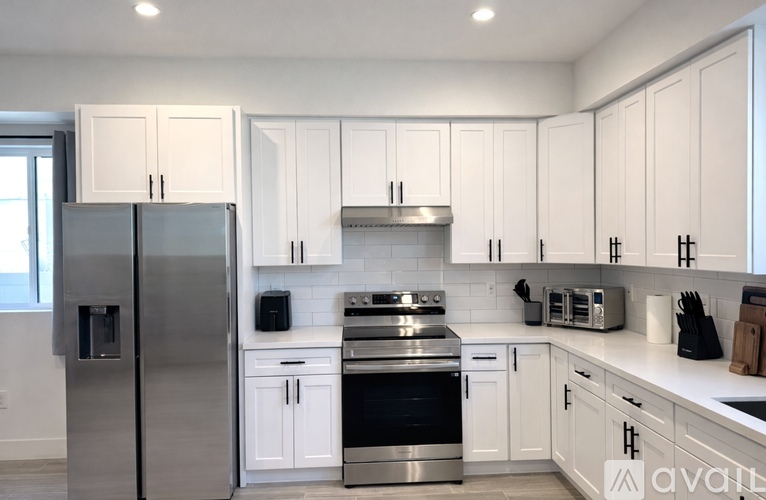 A kitchen with white cabinets and stainless steel appliances.
